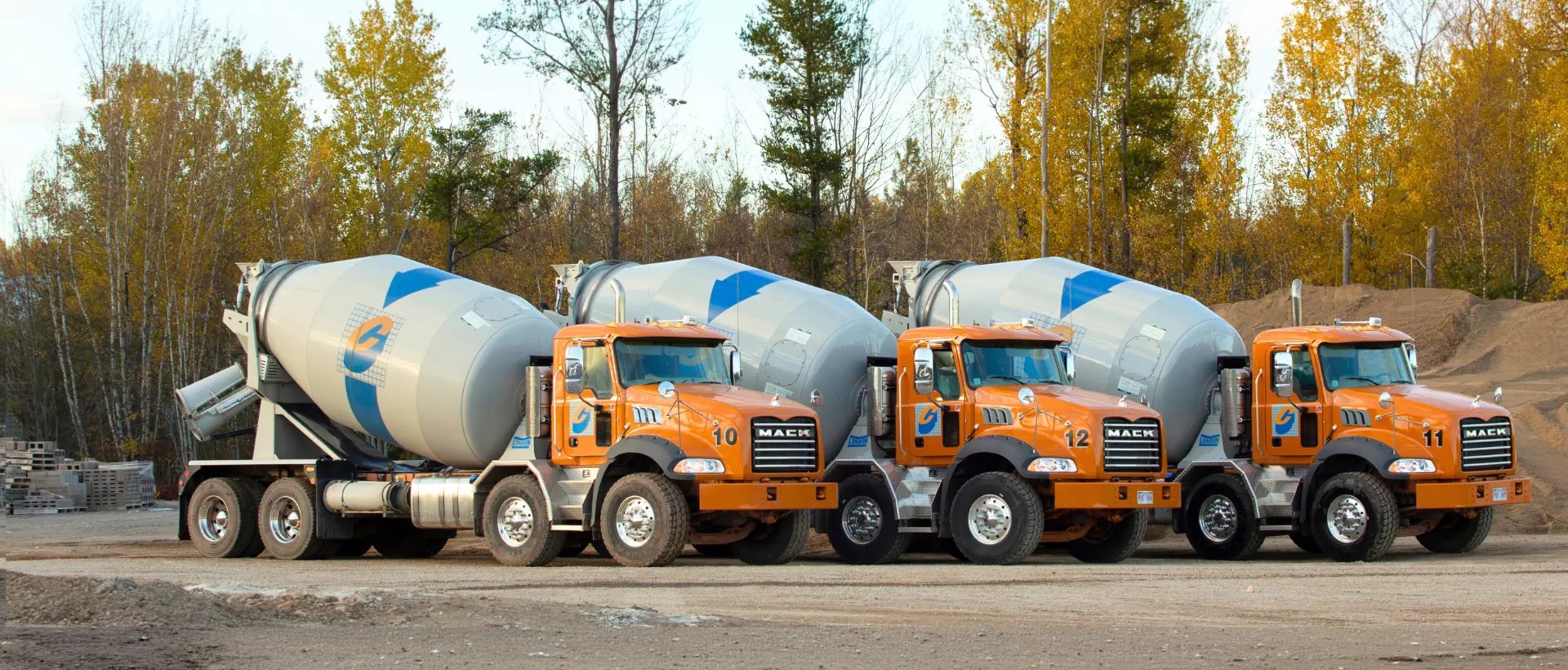 Casey Concrete fleet of orange Mack ready-mix trucks at the production yard